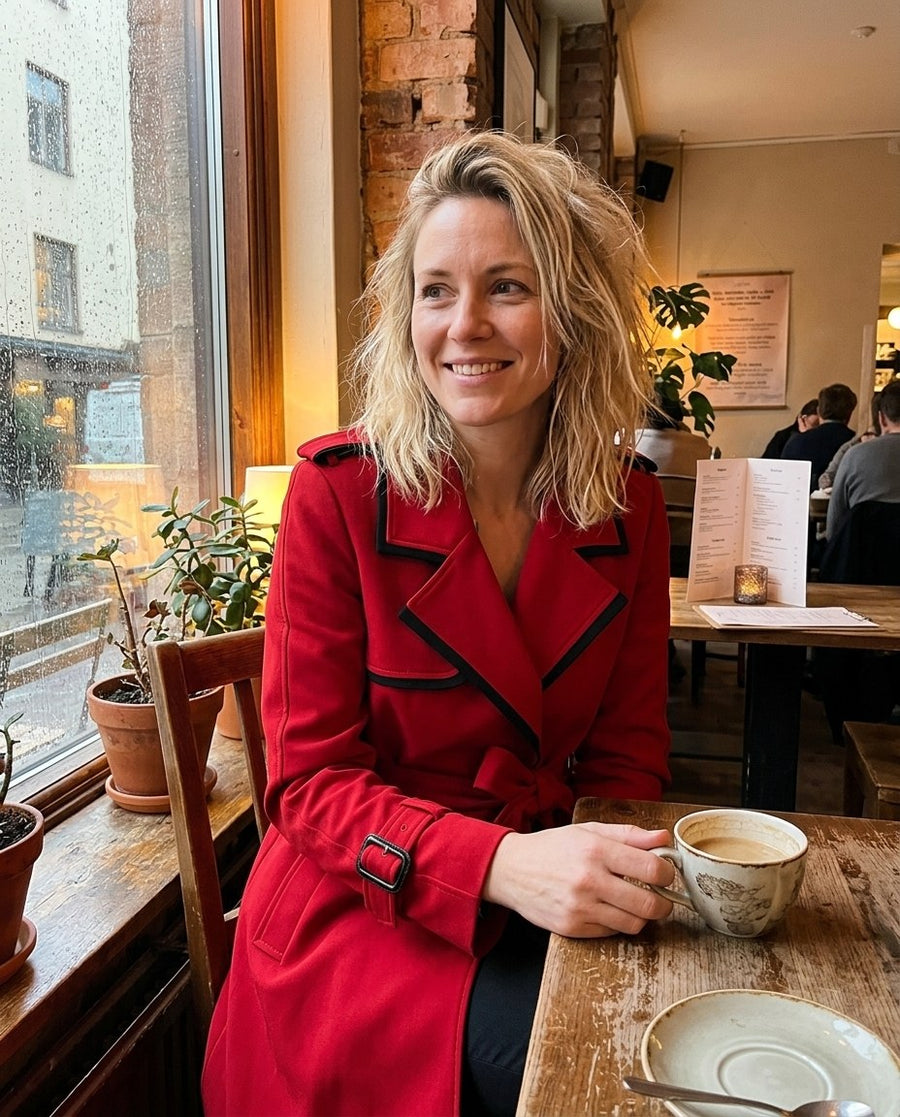 Sophia, damtrenchcoat med midja och knäppning i röd, stylinginspiration på ett kafé