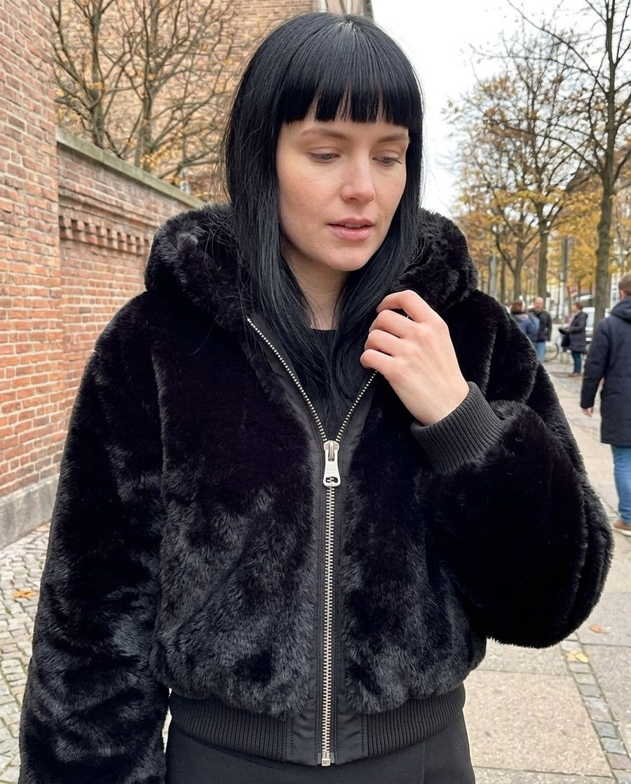Stina, fuskpälsjacka med huva för dam i svart, stylinginspiration närbild på materialet