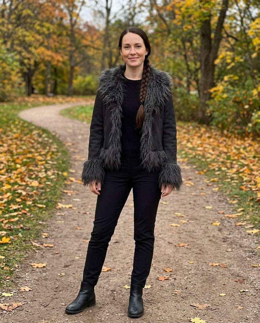 Selma, kort jacka med fuskpälskant för dam i svart, stylinginspiration i en höstpark
