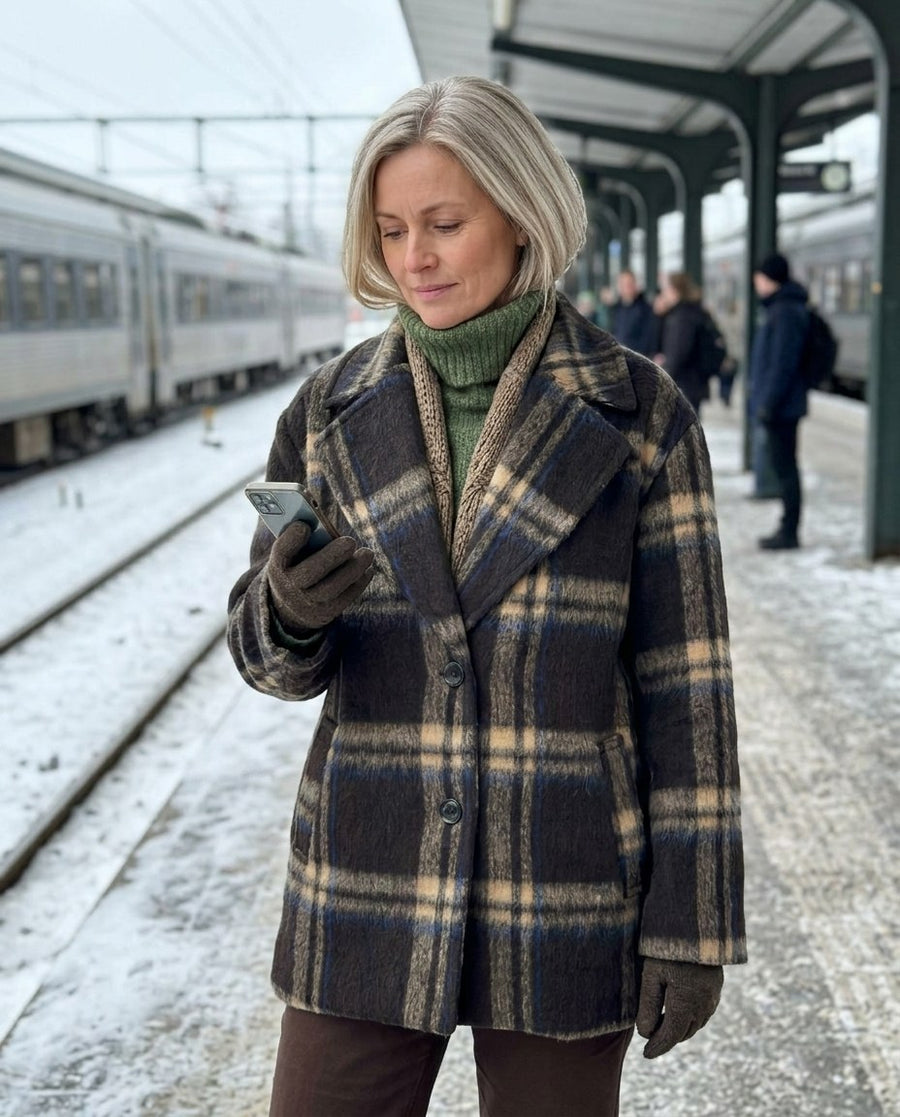 Hanna, kort rutig kappa för dam i brunrutig, stylinginspiration på en perron