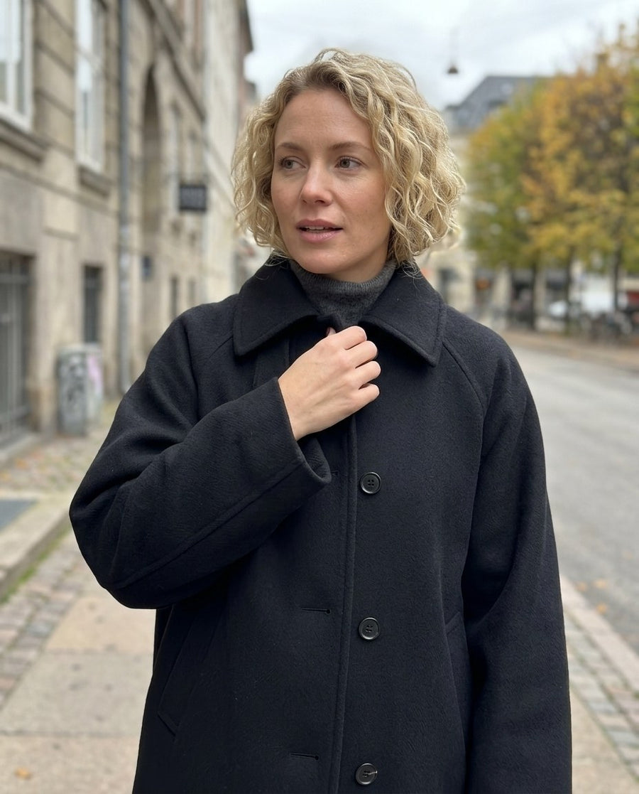 Kort ullkappa | enkelknäppt | lös passform | rymlig ullkappa | ulltrenchcoat dam, kort ullkappa | enkelknäppt | lös passform | rymlig ullkappa | ulltrenchcoat dam i svart, stylinginspiration närbild på materialet