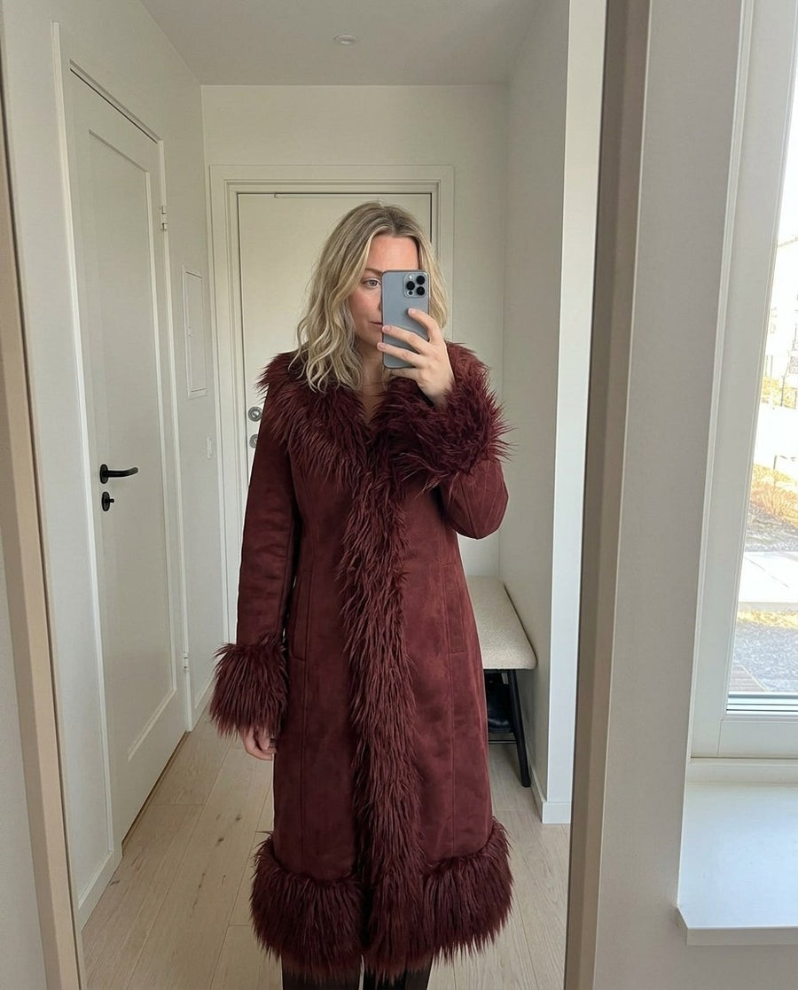 Lova, lång kappa i mockaimitation med fuskpälskant för dam i rödbrun, stylinginspiration spegelbild i hallen