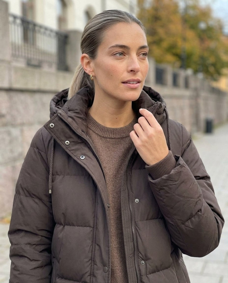 Tyra, lång vadderad jacka med huva för dam i brun, stylinginspiration närbild på materialet
