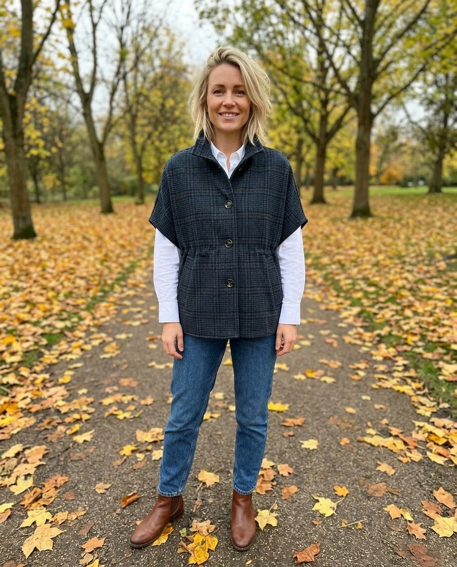 Liv, rutig cape i ullmix för dam i mörkblå, stylinginspiration i en höstpark