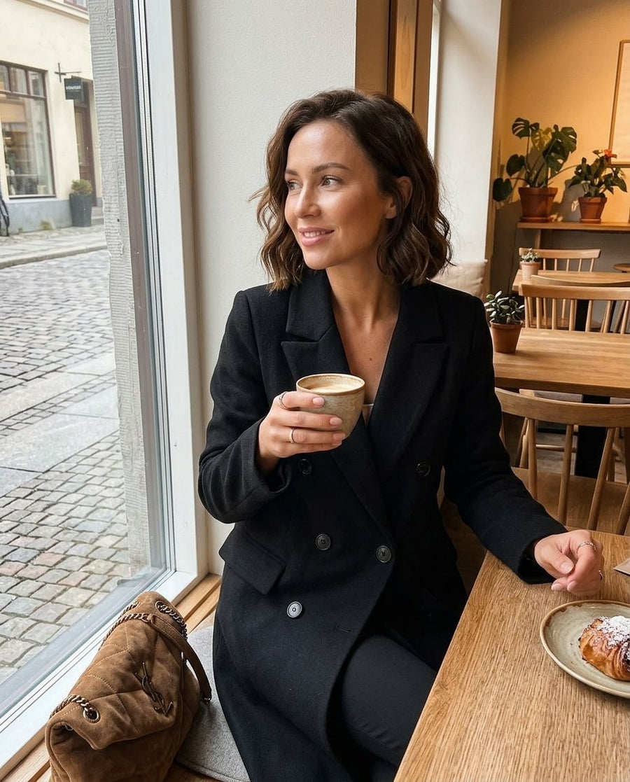 Lång dubbelknäppt kappa i ullmix för kvinnor, trenchcoat i ull i svart, stylinginspiration på ett kafé