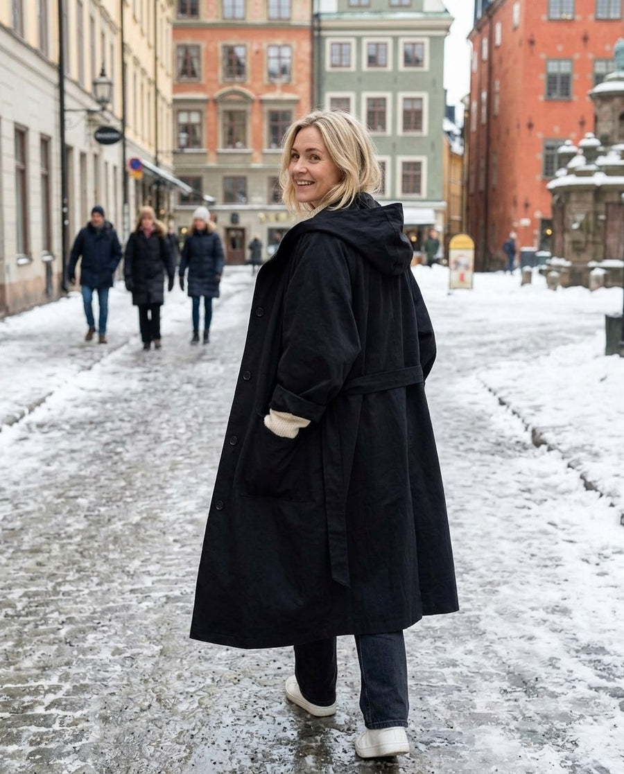 Maren höstutgåva, modetrogen oversized trenchcoat för dam i svart, stylinginspiration på en snöig gata