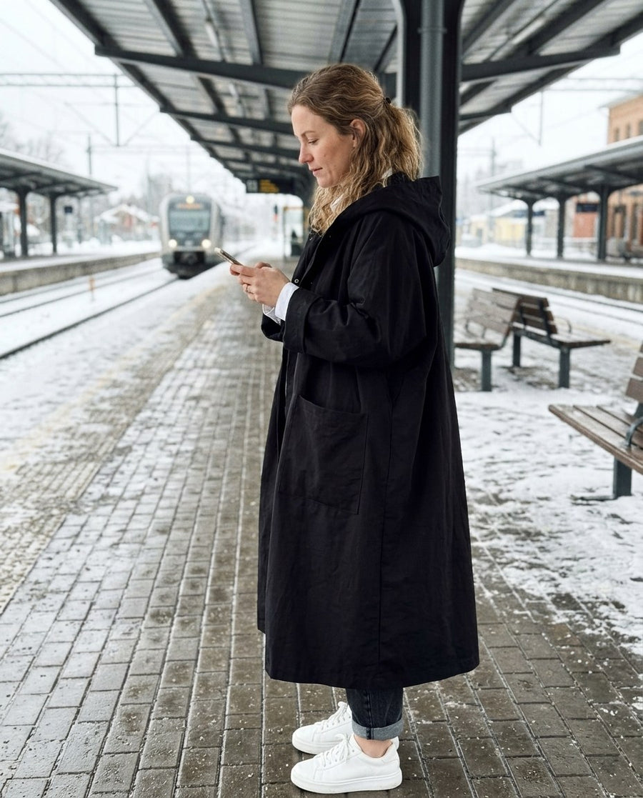 Maren höstutgåva, modetrogen oversized trenchcoat för dam i svart, stylinginspiration på en perron