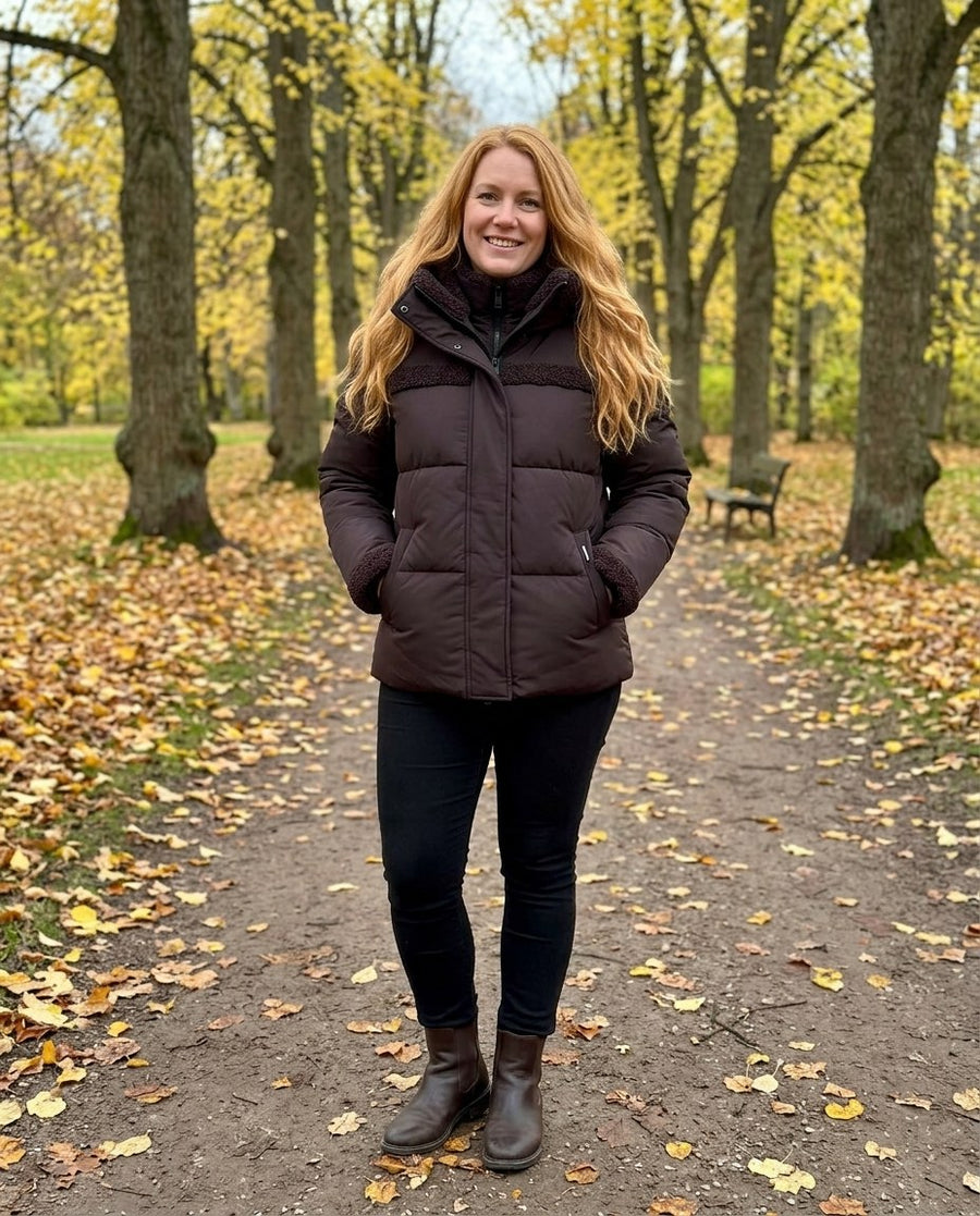 Signe, vadderad 2-i-1-jacka med huva för dam i mörkbrun, stylinginspiration i en höstpark